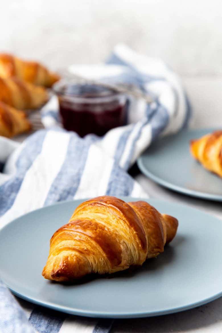 Serving croissants on a plate with jam on the side