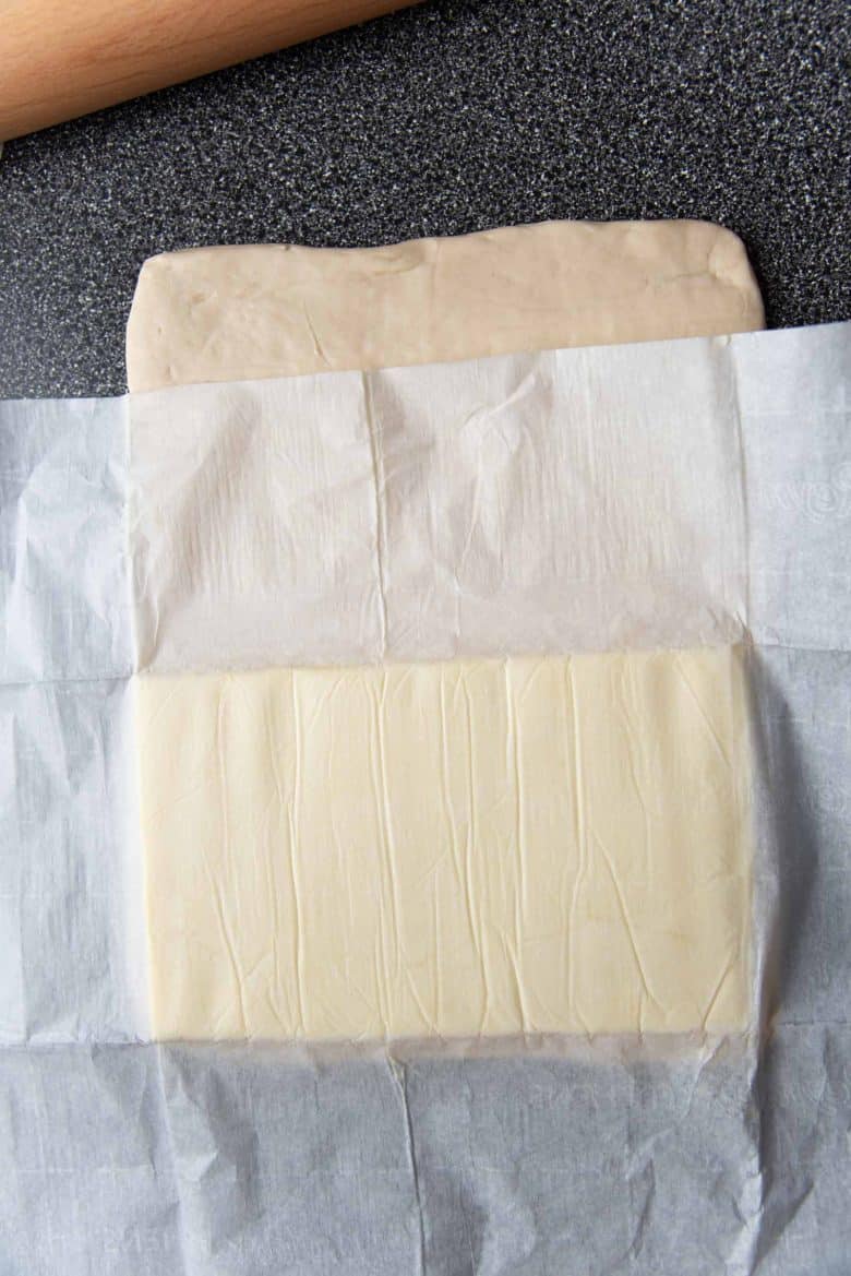 An overhead view of placing the butter block on one half of the dough