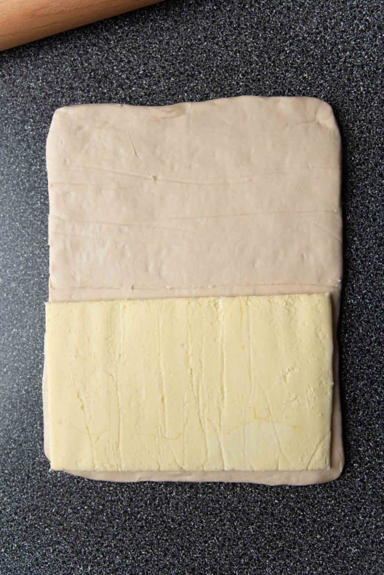 The butter block kept on the dough, without the parchment paper attached.