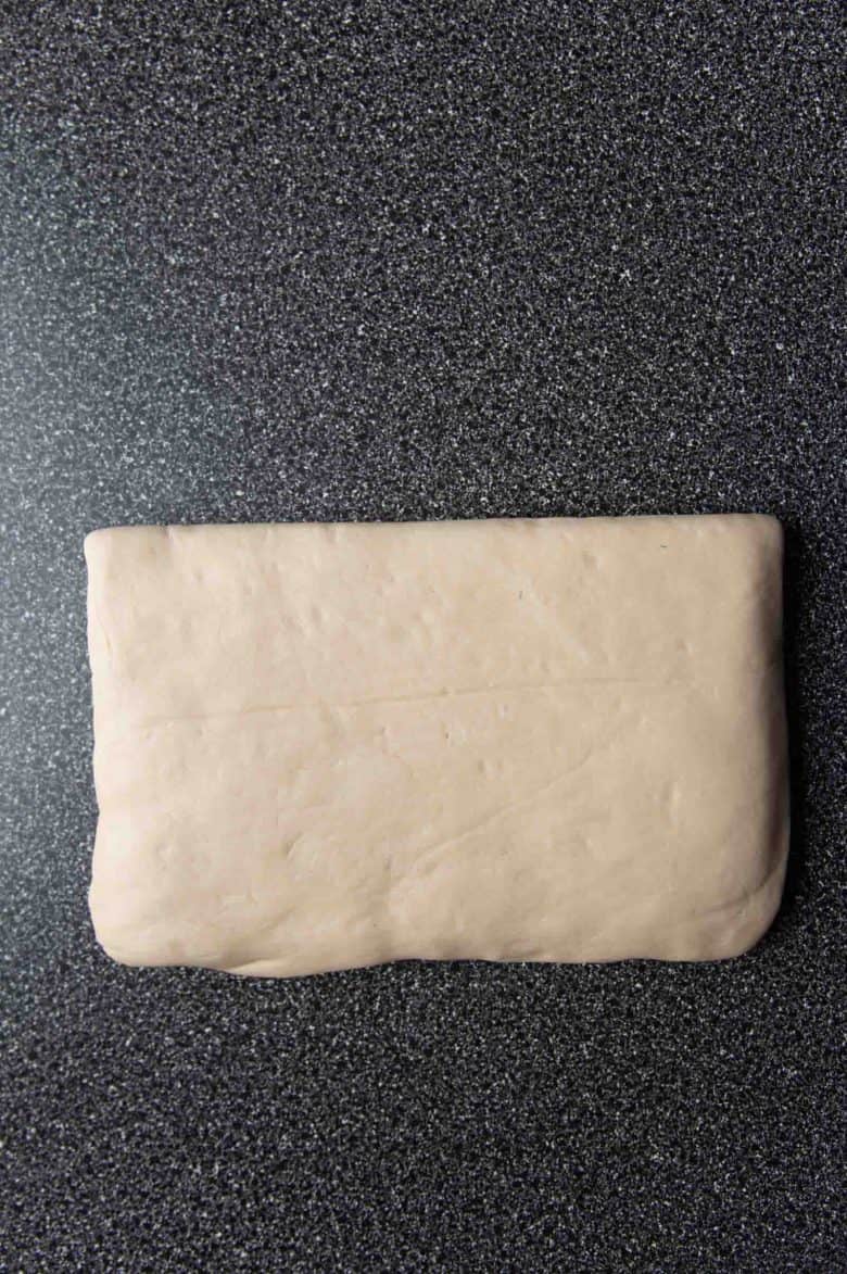 The dough folded over the butter, to enclose the butter before the lamination process.