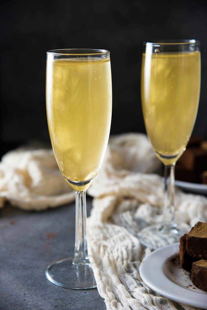 Two champagne glasses with gold shimmery champagne cocktail.