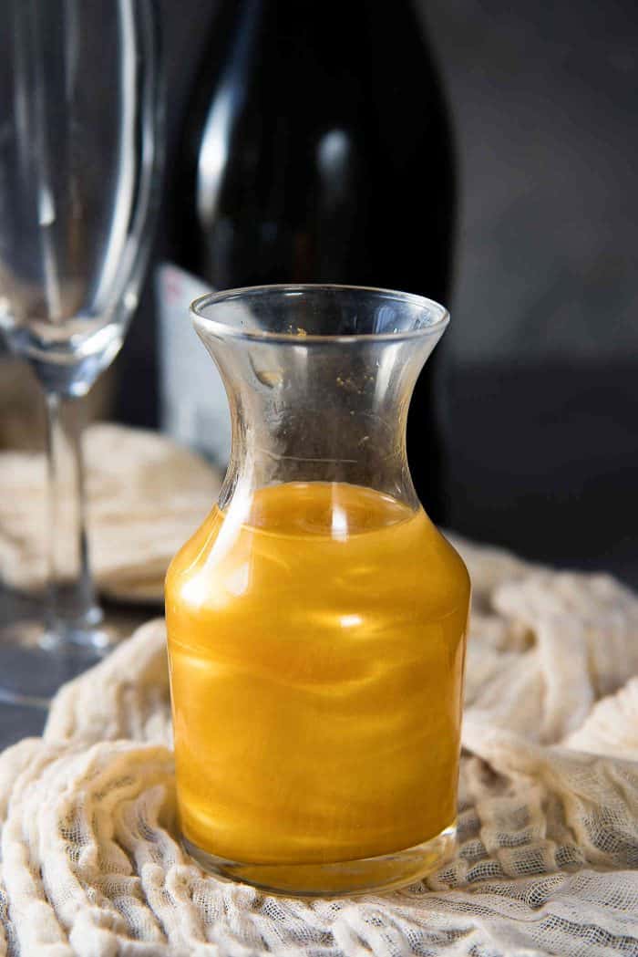 Bright gold shimmery liqueur in a small glass bottle.