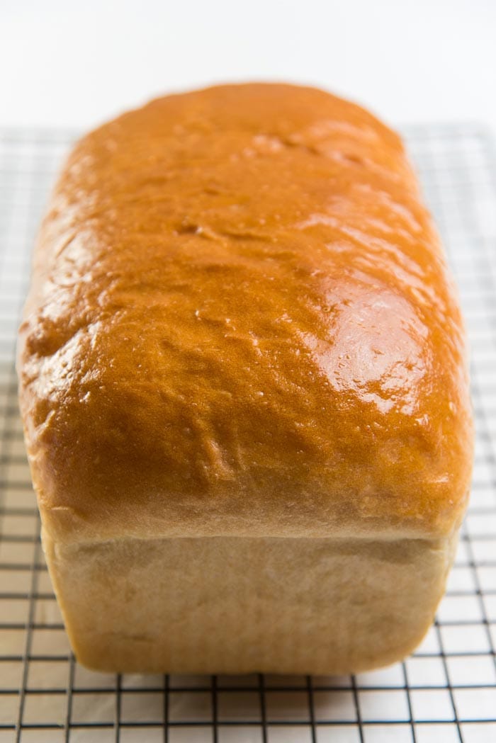 Baked homemade bread loaf cooling down on a wire rack.