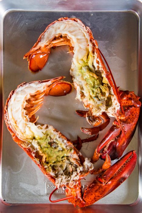 A whole lobster cut in half, showing the green tomalley.