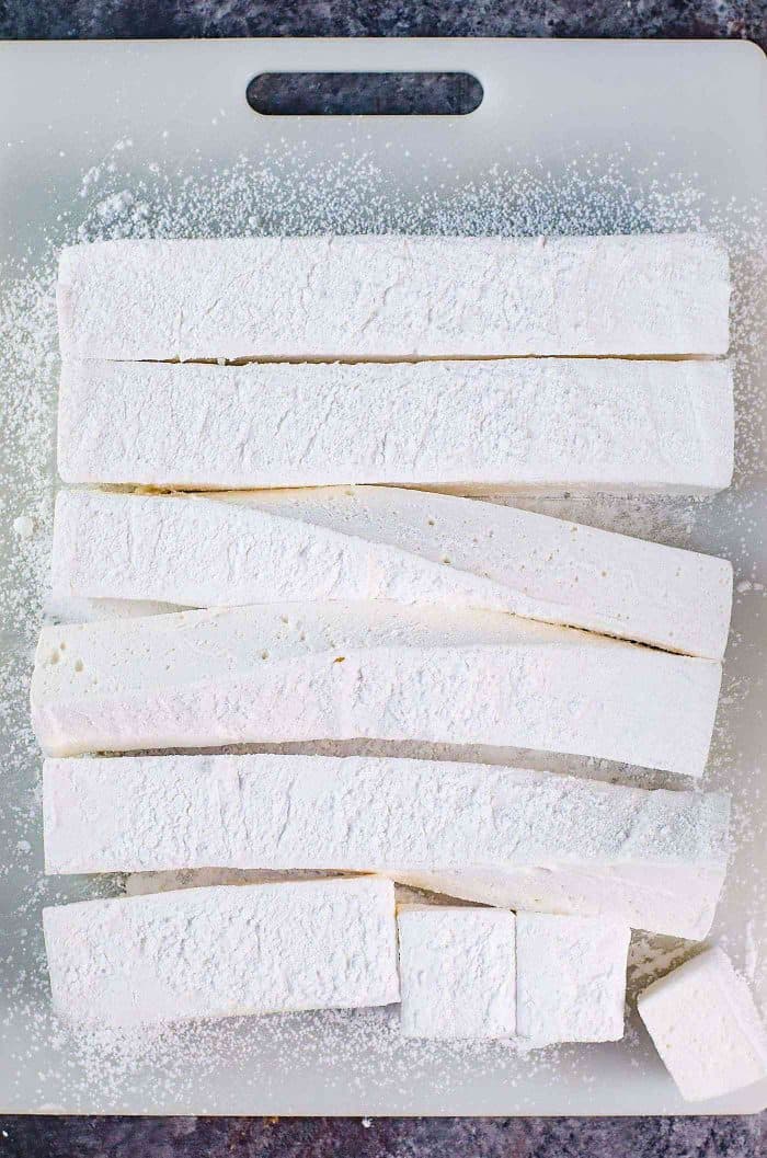 Homemade marshmallows being cut into strips and squares