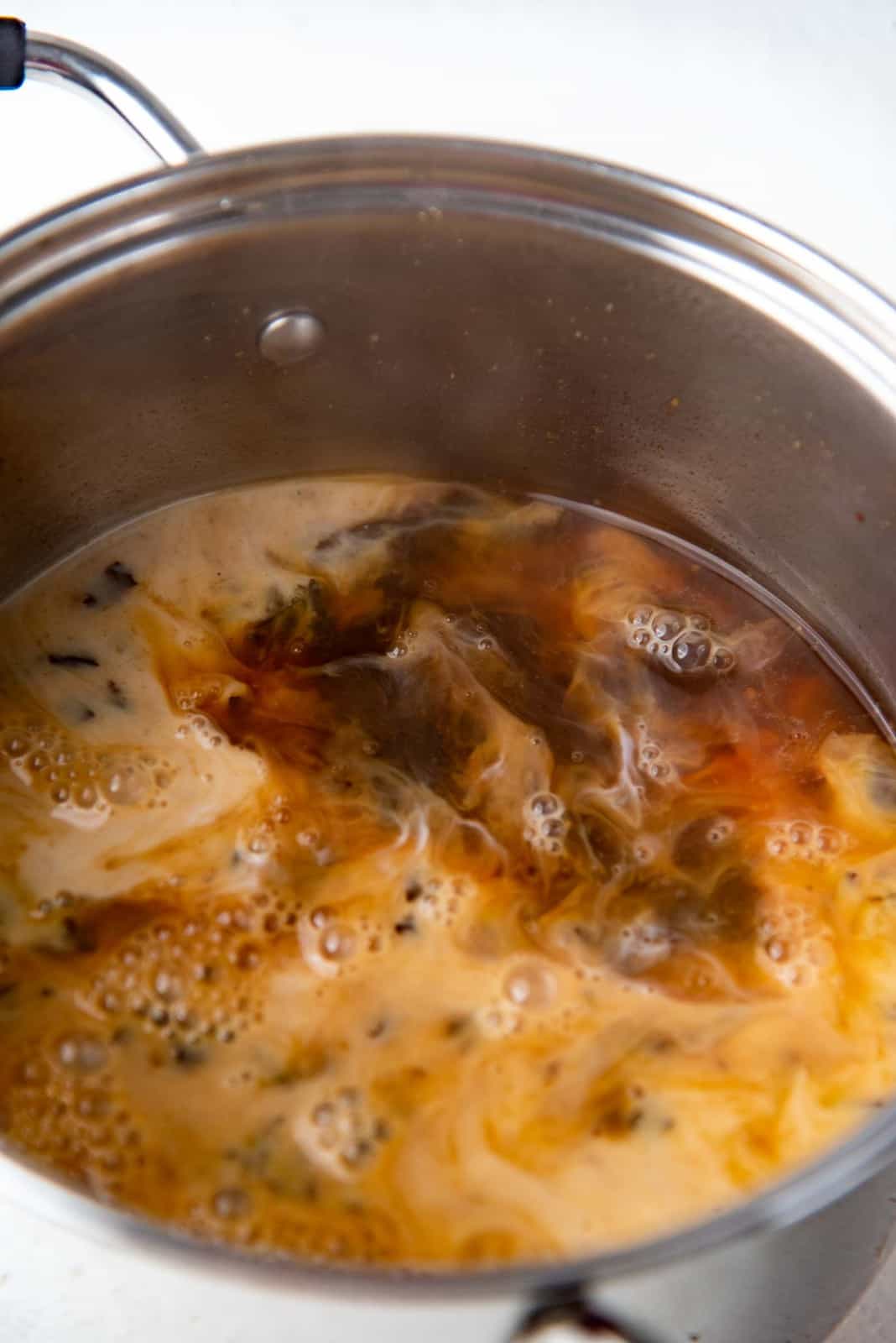 Adding milk to the tea base