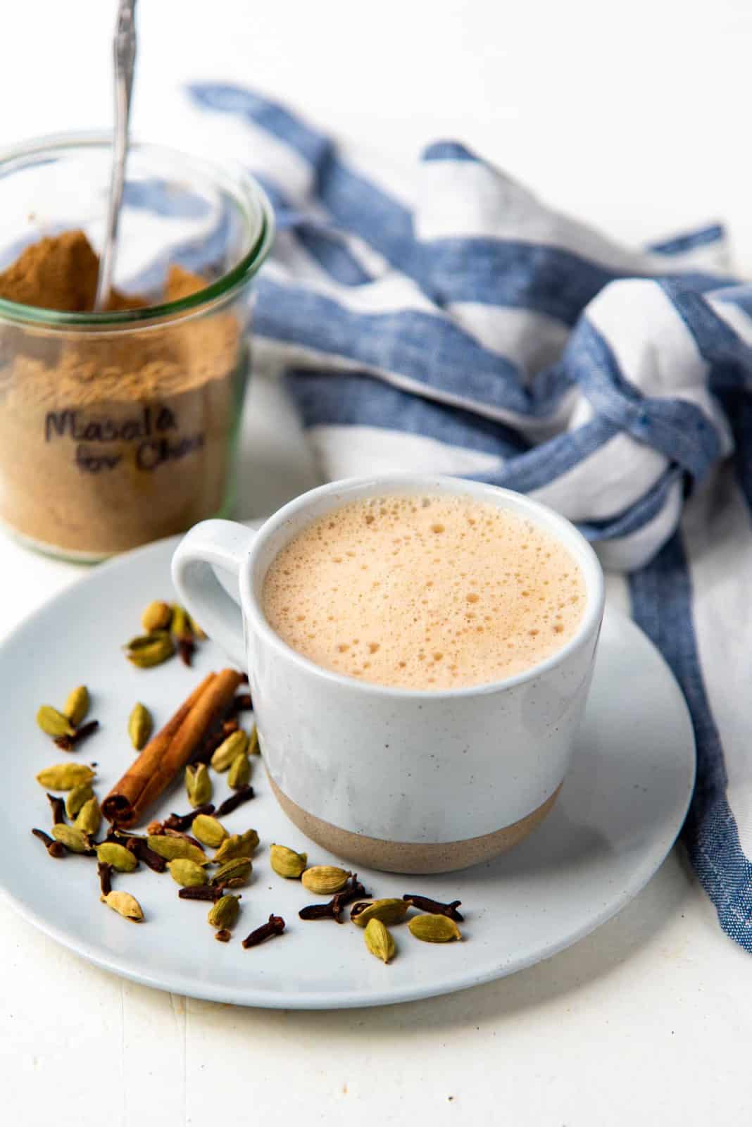 Masala Chai served in a mug with the spice mix in a jar