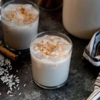 Glass of Mexican horchata served with ice and topped with a sprinkling of cinnamon.
