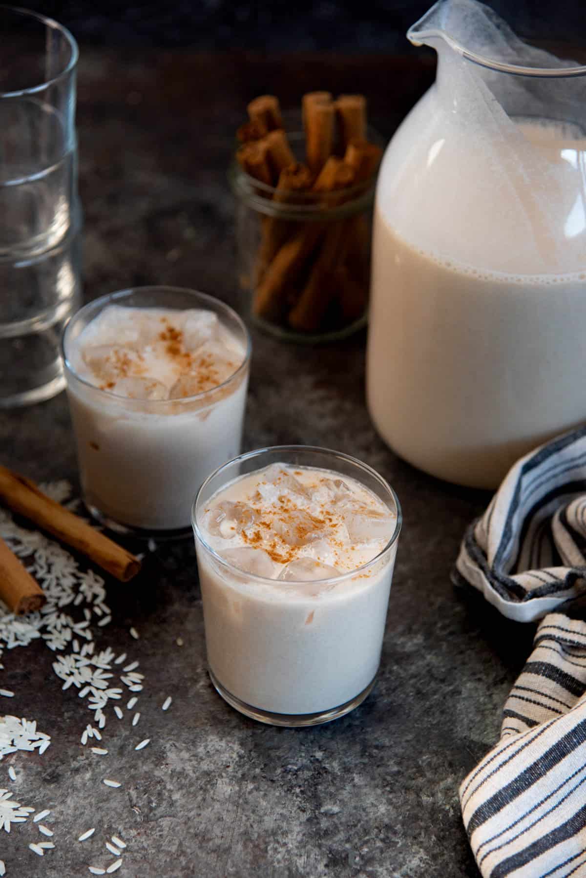 Mexican rice milk (horchata) in a glass, served with ice and a sprinkling of cinnamon on top.