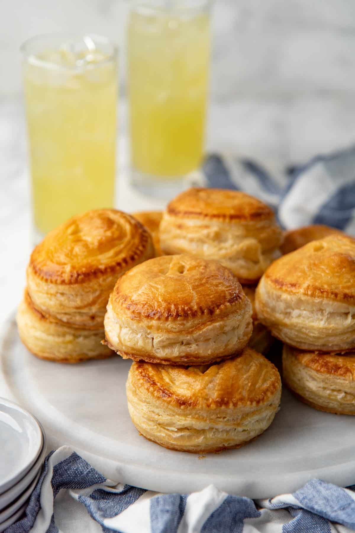 Stacks of mini chicken hand pies on a grey platter.