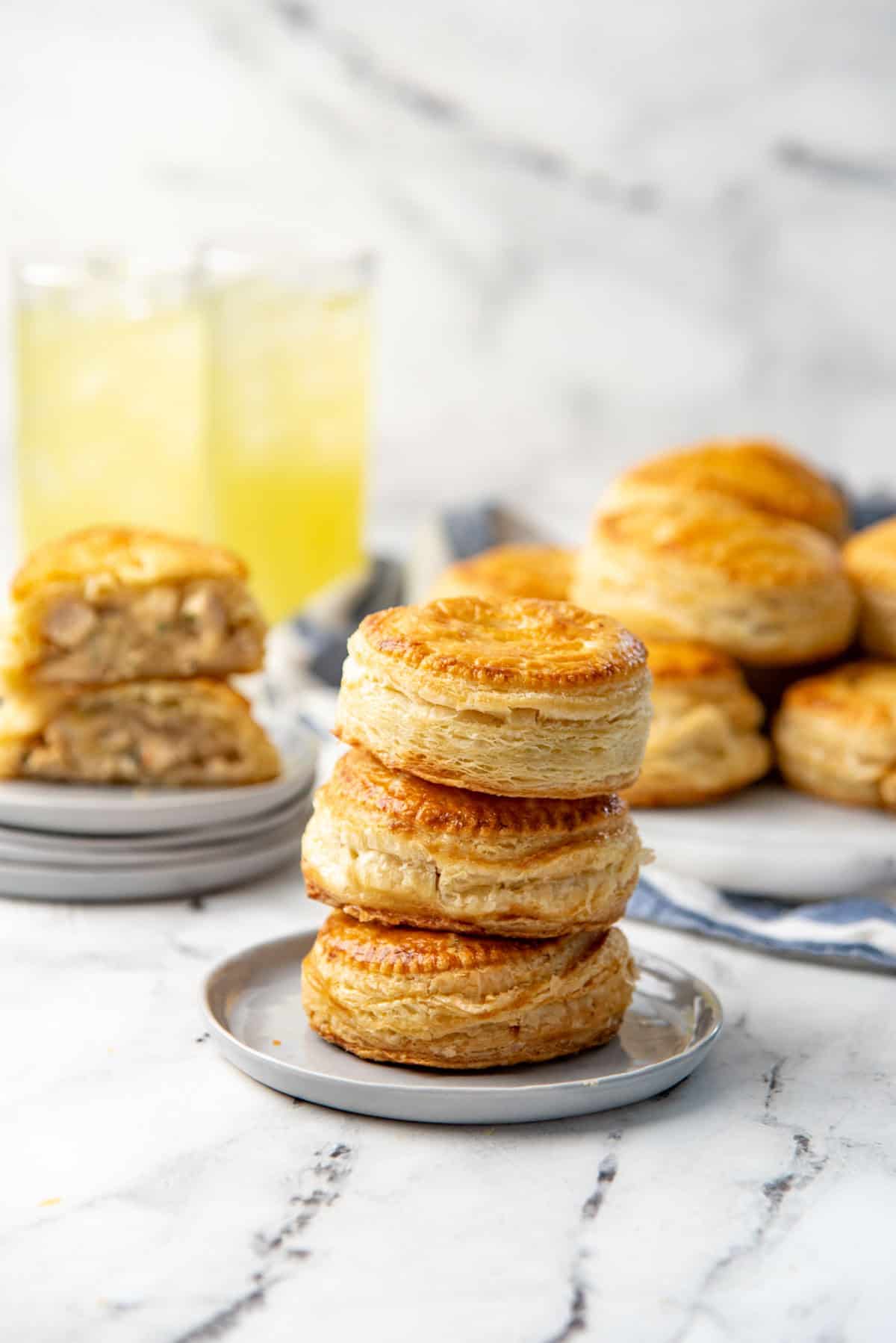 Three mini puff pastry chicken pies stacked on top of each other on a small plate.