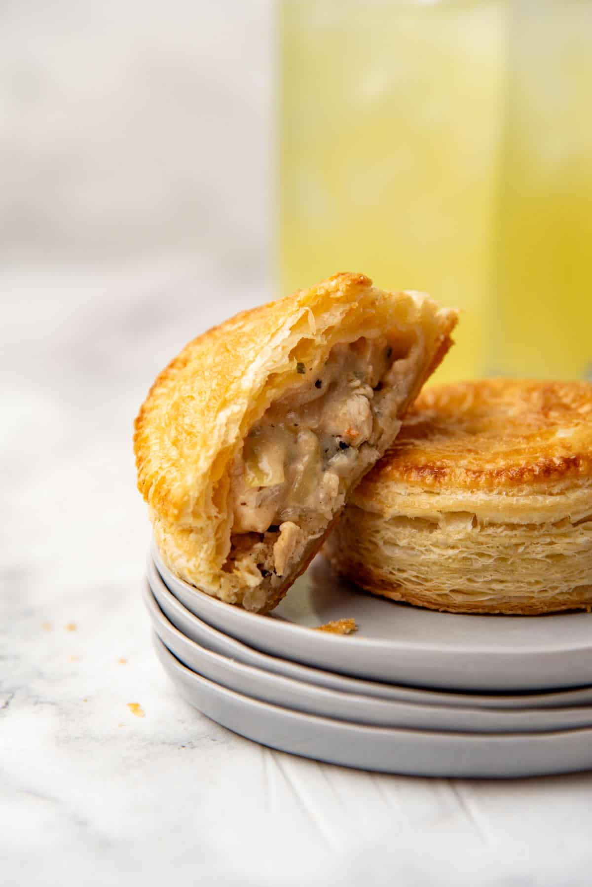 A mini cheesy chicken pie cut in half to show the consistency of the creamy, cheesy chicken filling.