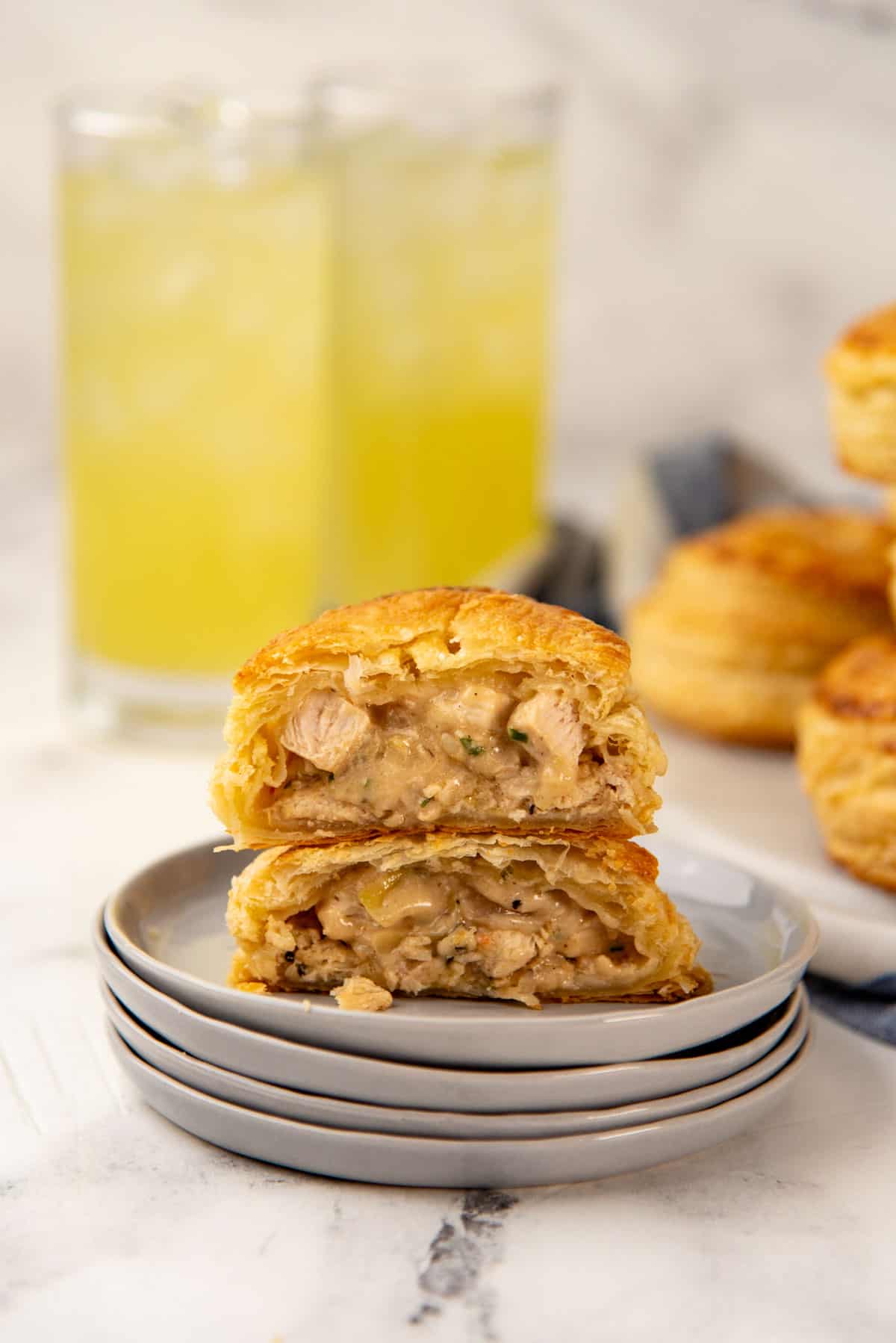 One chicken hand pie cut in half and placed on a small grey plate.