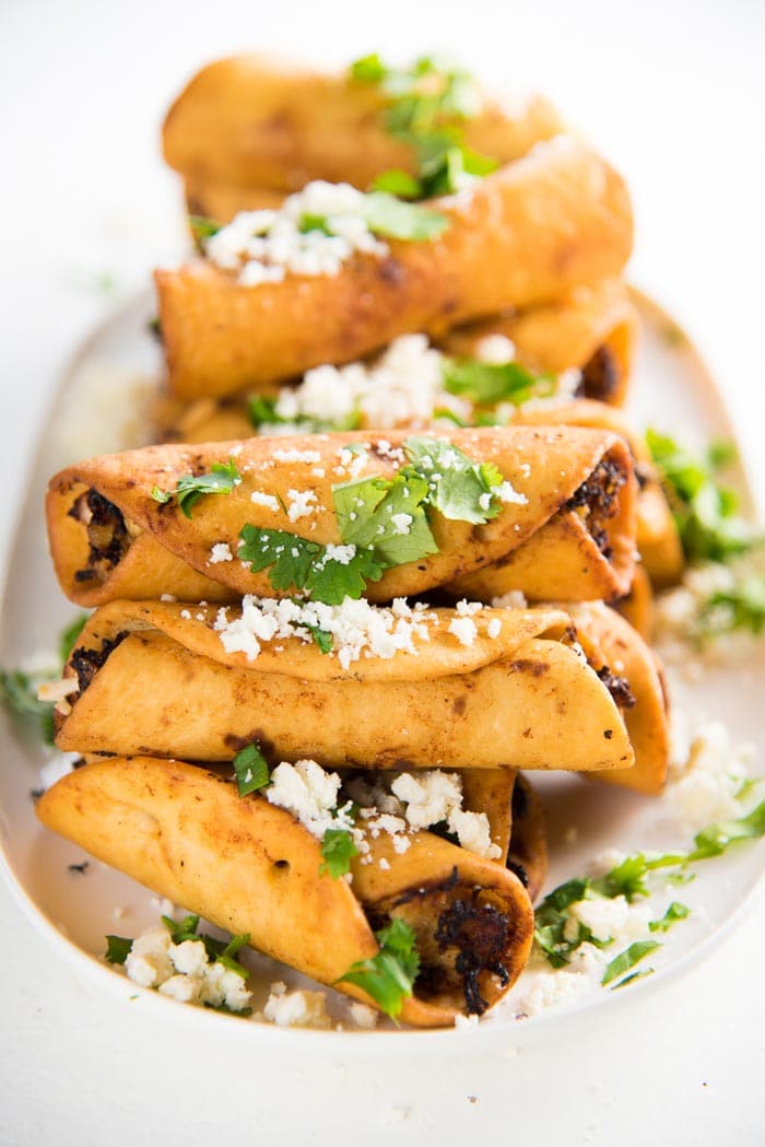 Mini Chicken Taquitos - Crispy mini taquitos filled with a creamy, tangy chicken and cheese filling, perfect as appetizers for any party. Make these as a snack, appetizer or even as a meal.