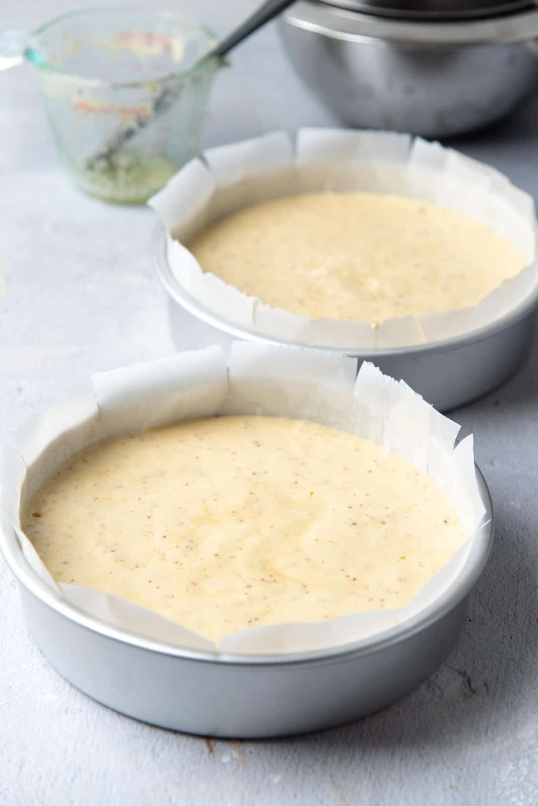 The cake batter divided between two cake pans