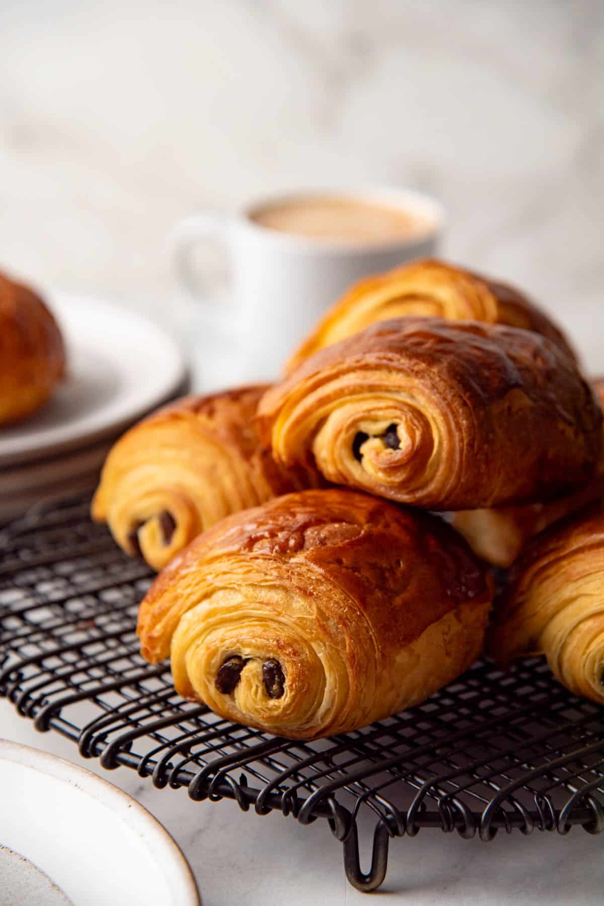 Stack of baked pain au chocolat on a cooling rack showing all the flaky layers.