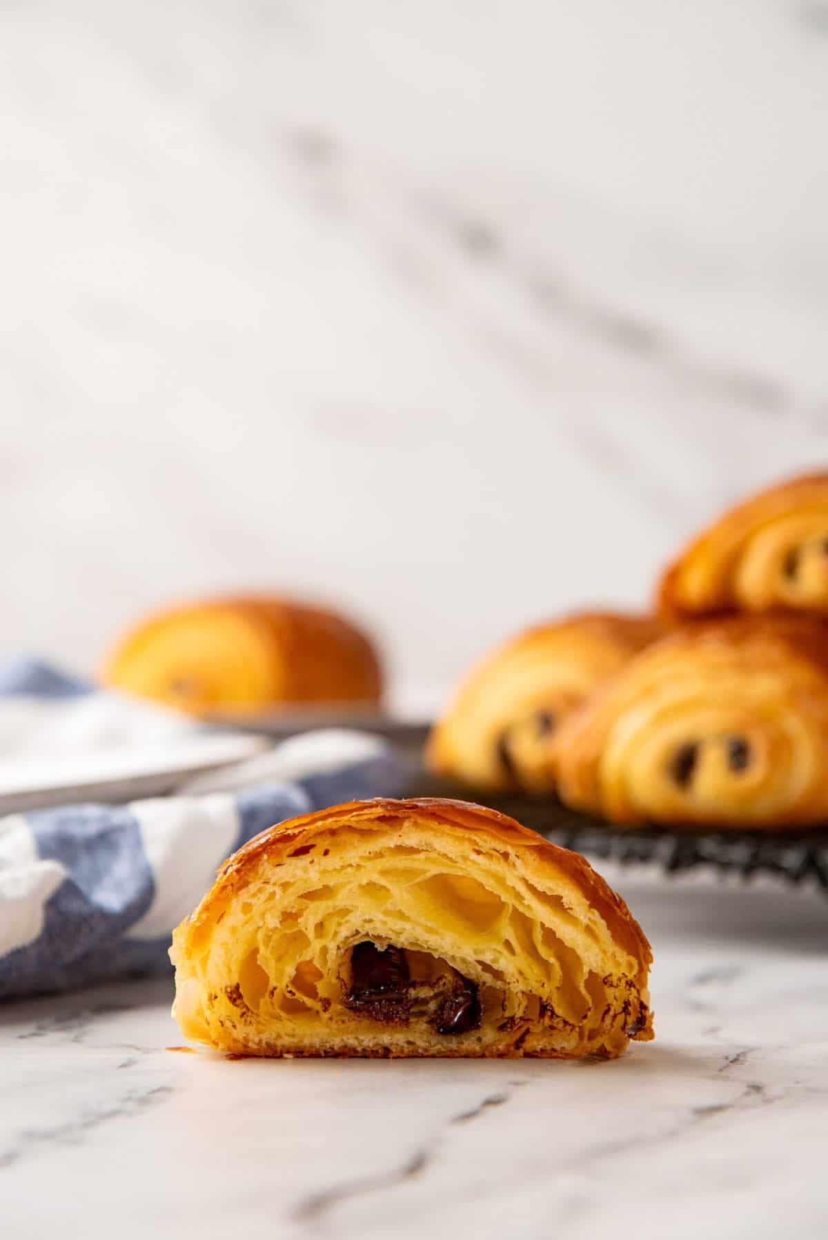A chocolate croissant half showing the airy honeycomb structure and chocolate stick inside.