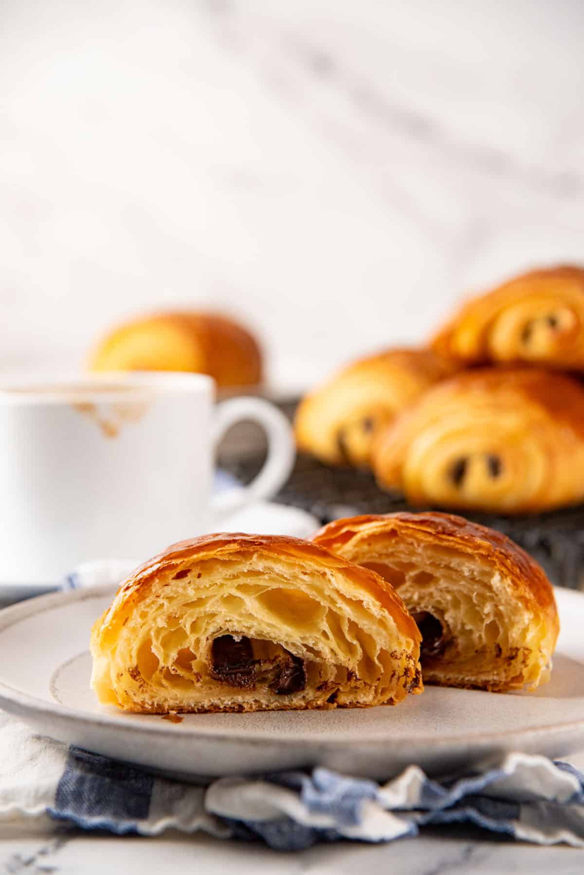 A pain au chocolat cut in half to show the honeycomb structure and chocolate baton inside.