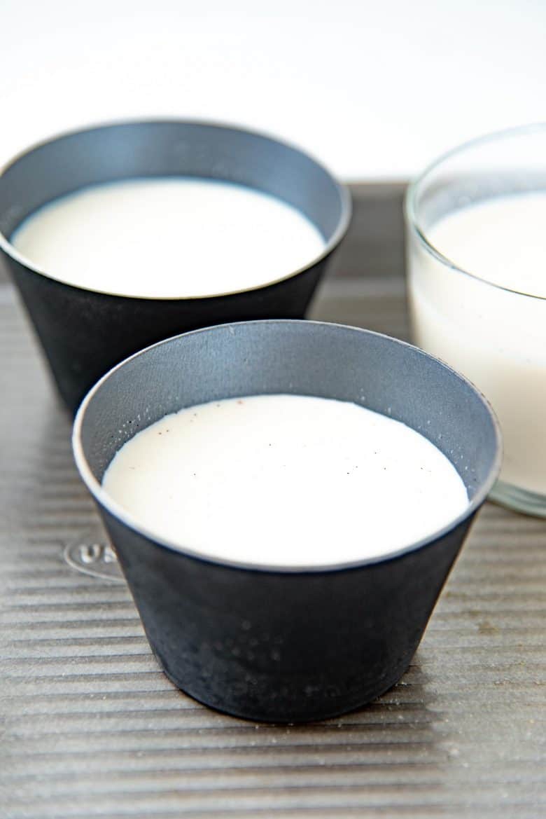 Panna cotta poured into metal ramekins, used to unmold the dessert