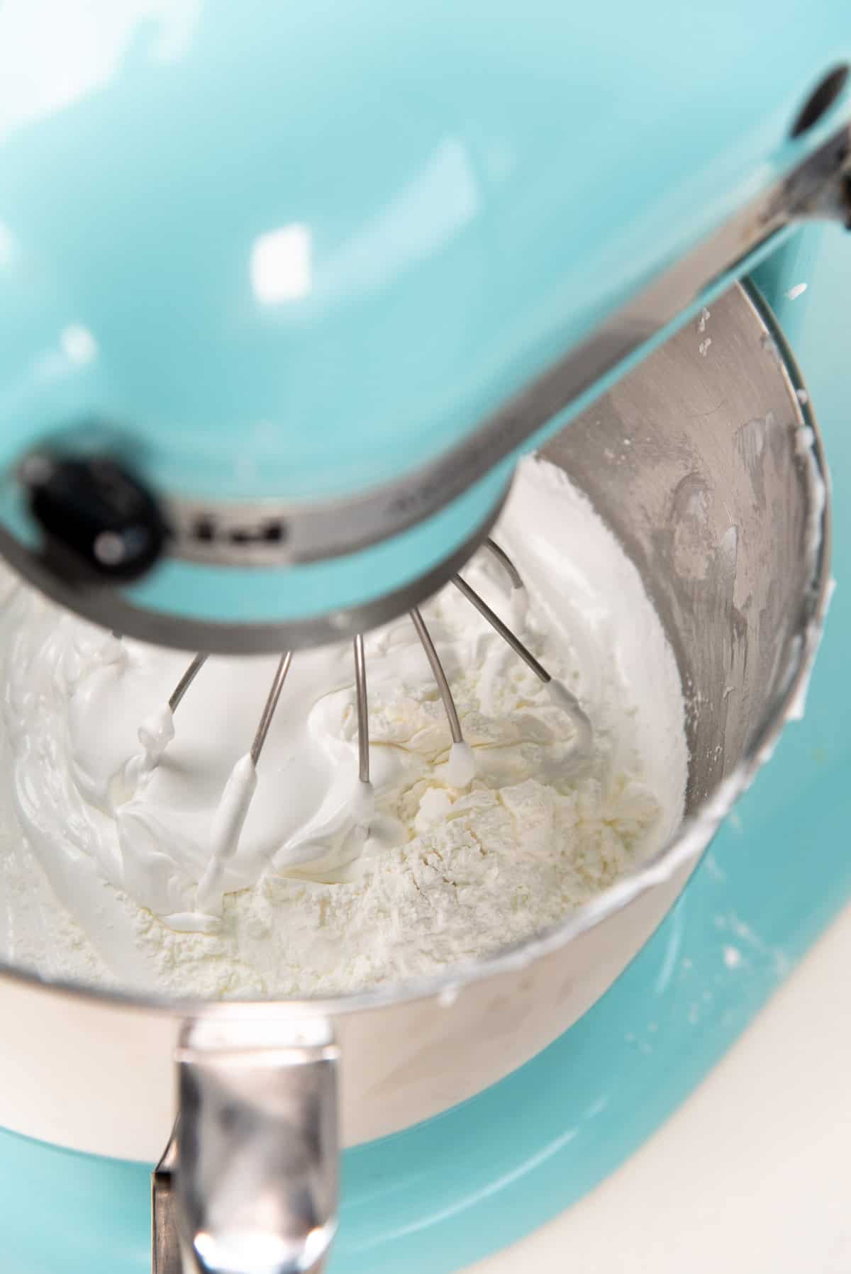 A close up view of the cornstarch and acid being mixed in slowly, by pulsing the mixer.