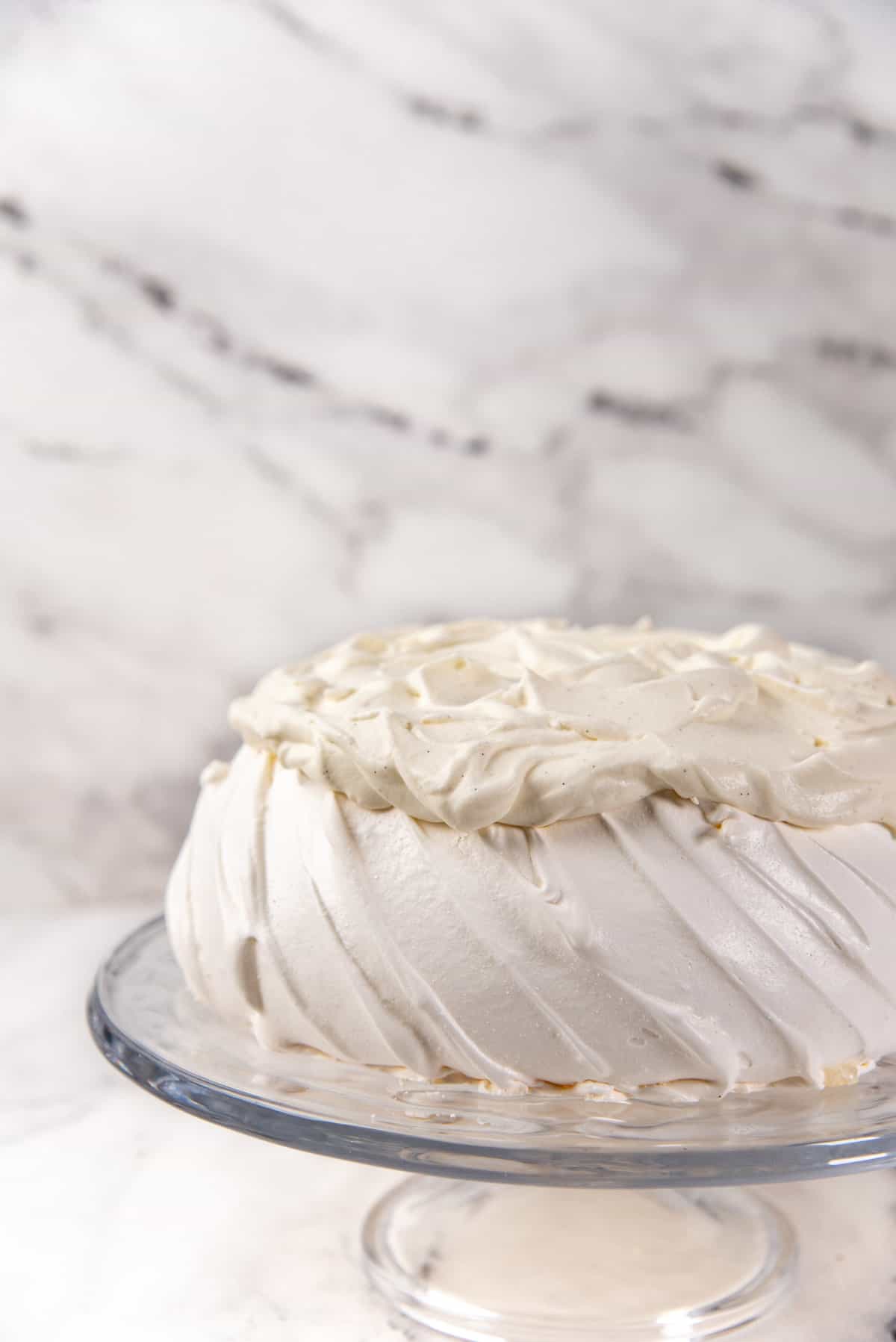 The pavlova topped up with a layer of whipped cream spread evenly on top.