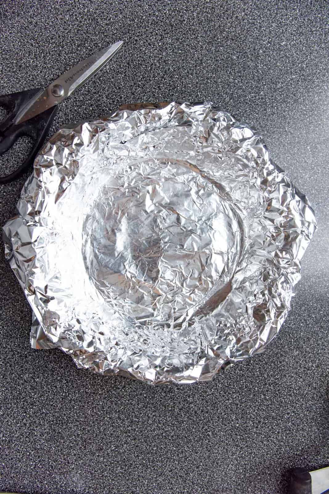 A piece of foil fitted into the pie plate, ontop of the pie crust.