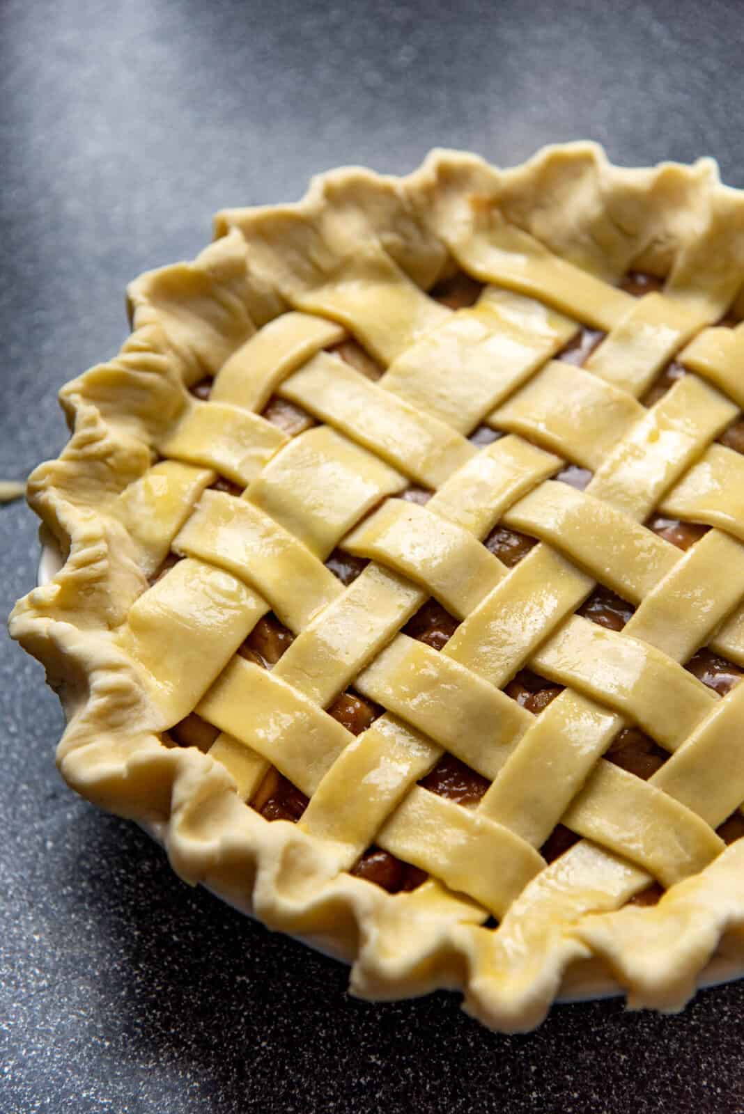 A sealed, fluted and prepped double crusted fruit pie before baking.