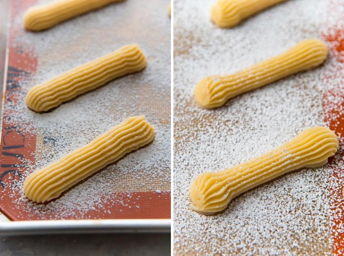 Choux Pastry piped to make eclairs, in two different shapes, and dusted with confectioner's sugar