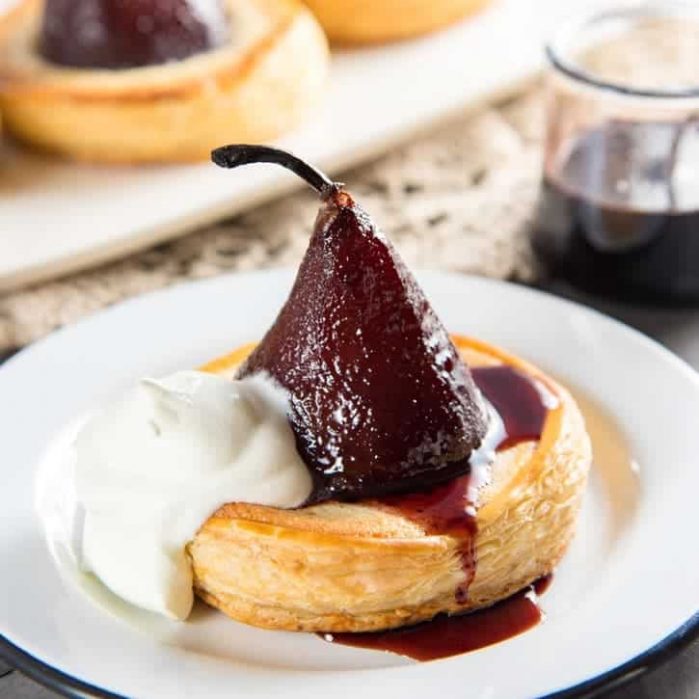 Delicious poached pear tarts, baked in frangipane and filled with a gooey chocolate filling. A show-stopping dessert!