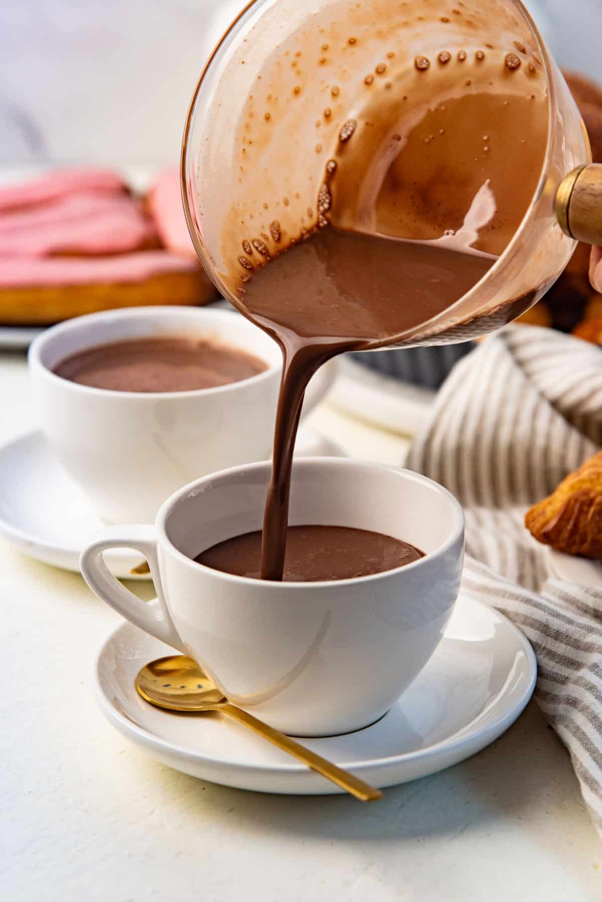 French hot chocolate being poured into a small coffee cup for serving.