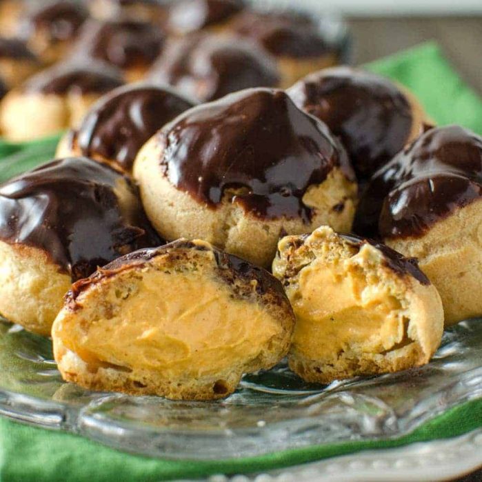 Pumpkin Cheesecake Profiteroles - Bitesized Profiteroles filled with creamy Pumpkin Cheesecake filling and a chocolate glaze. Perfect for Fall and for thanksgiving!