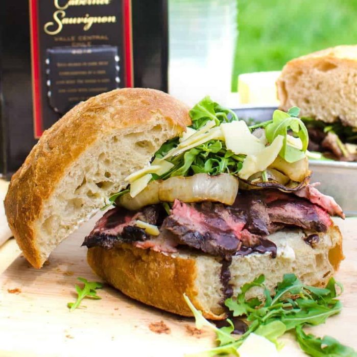 [Msg 4 21+] Red Wine marinated Steak Sandwiches with a Red wine Glaze, Grilled Onions, Arugula and Aged Cheddar. Red wine marinated, succulent, perfectly grilled steak, sliced and piled on toasted bread topped with a buttery red wine glaze! A Perfect Picnic Sandwich! REPIN to save. CLICK to get the recipe now. #TheFlavorBender #BlackBoxSummer [ad]
