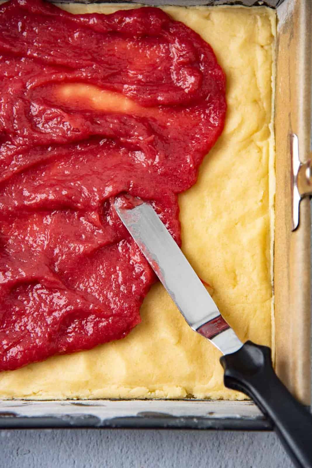 Spreading the rhubarb filling over the shortbread layer