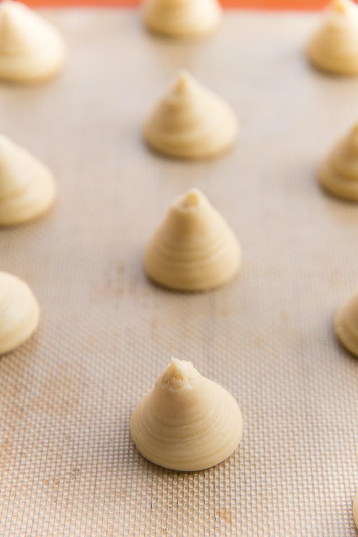 Choux pastry piped on a prepared baking tray.
