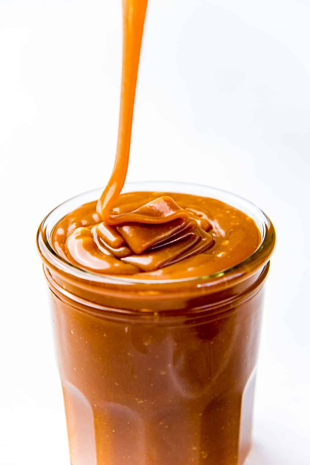 Pouring caramel sauce in glass jars
