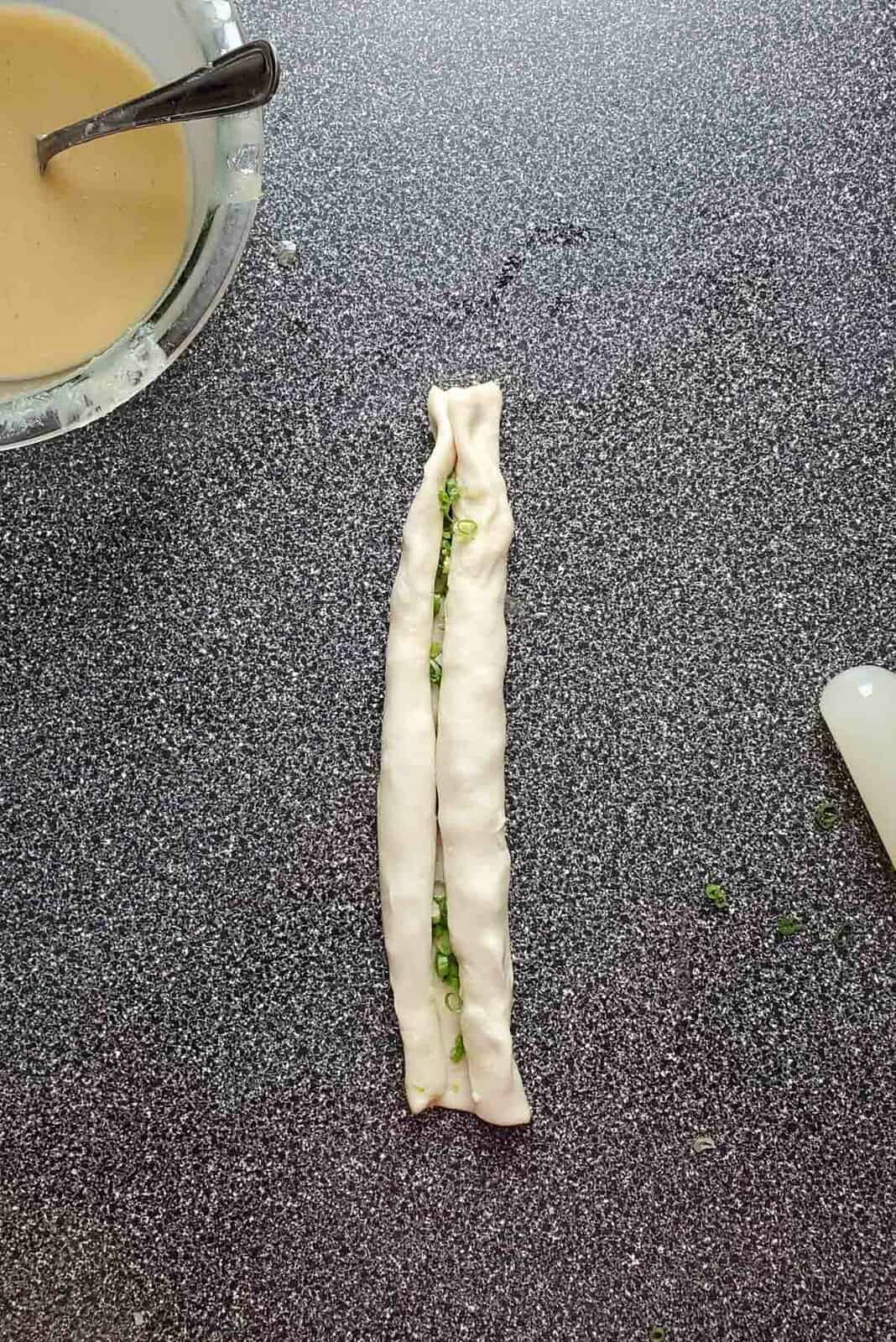 The rolled dough, after being rolled towards the middle.