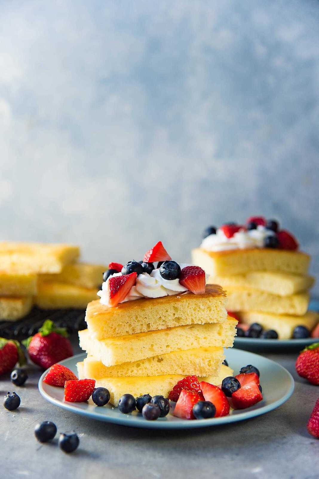 Sheet pan pancakes - Light and fluffy oven baked pancakes served with whipped cream and fresh berries.