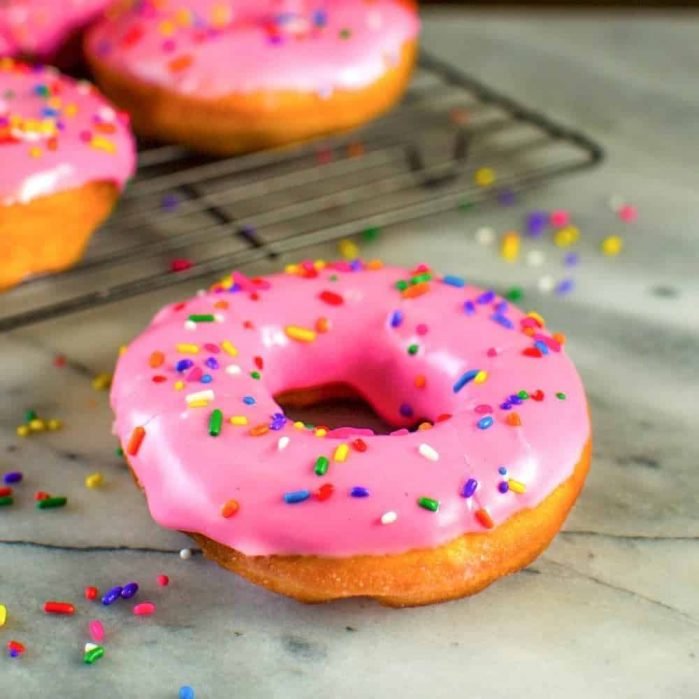 The Simpsons Doughnuts - These pink glazed doughnuts with sprinkles is Homer Simpsons favorite snack!  and now you can make them at home with a FULL TUTORIAL to make perfect doughnuts everytime!