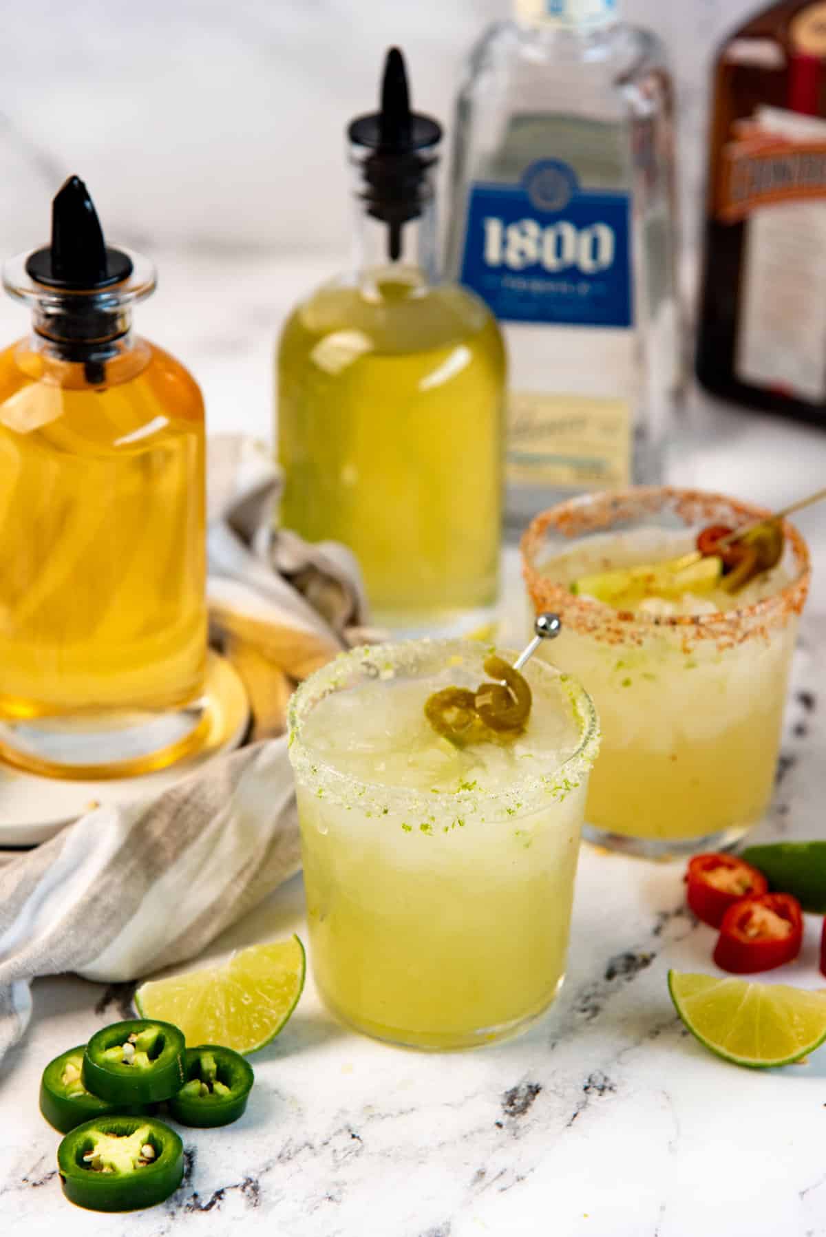 Spicy Jalapeno margarita served with lime salt rimmed glass with a pickled jalapeno and lime garnish.
