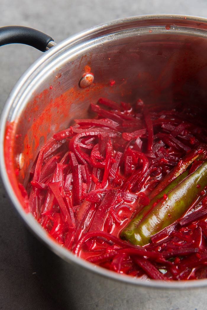 Beetroot curry after being cooked in a saucepan, with deep pink-red coconut gravy.