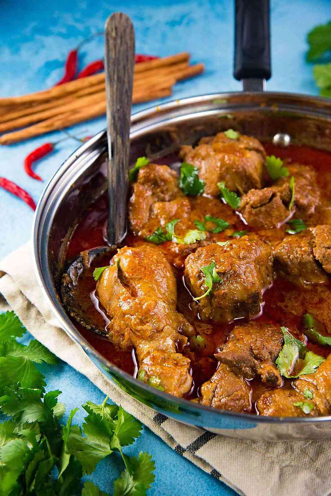 The best Sri Lankan Chicken Curry - delicious chicken curry served with a coconut spoon, with flavorful gravy.