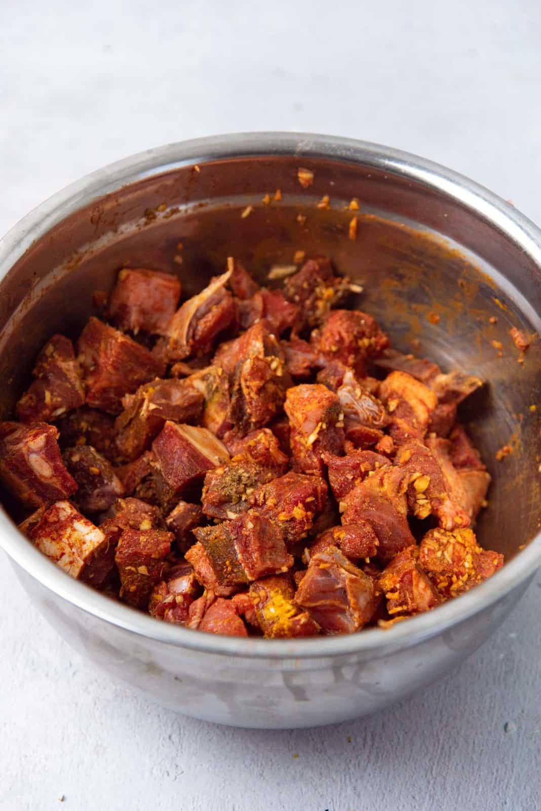 The cut up mutton mixed with curry spiced marinade.