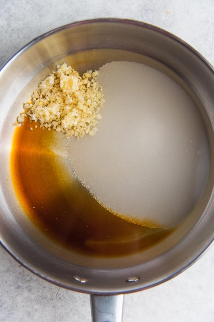 The first step of mixing the liquids, sugar and garlic in a saucepan until the sugar is melted.