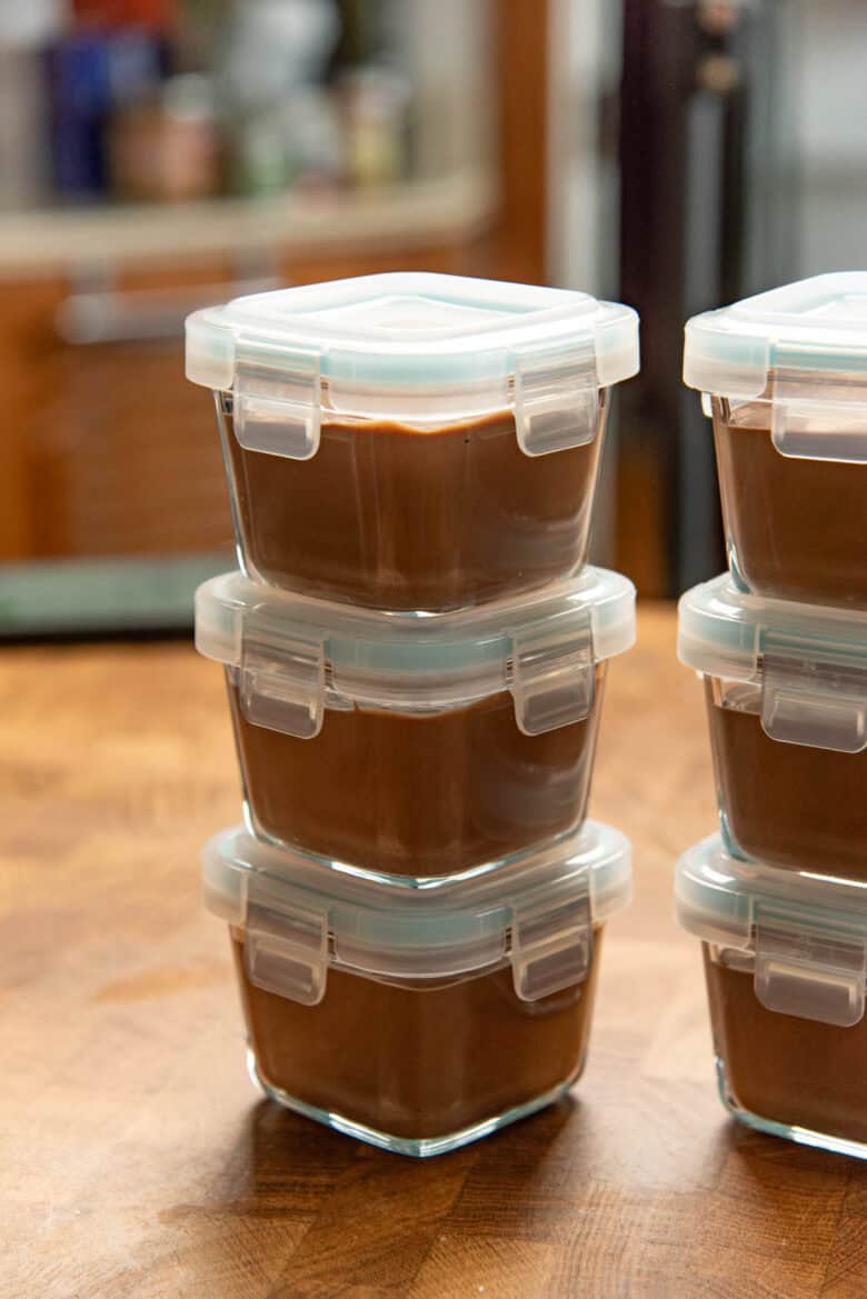 Stack of individual serving glass containers with tofu chocolate mousse.