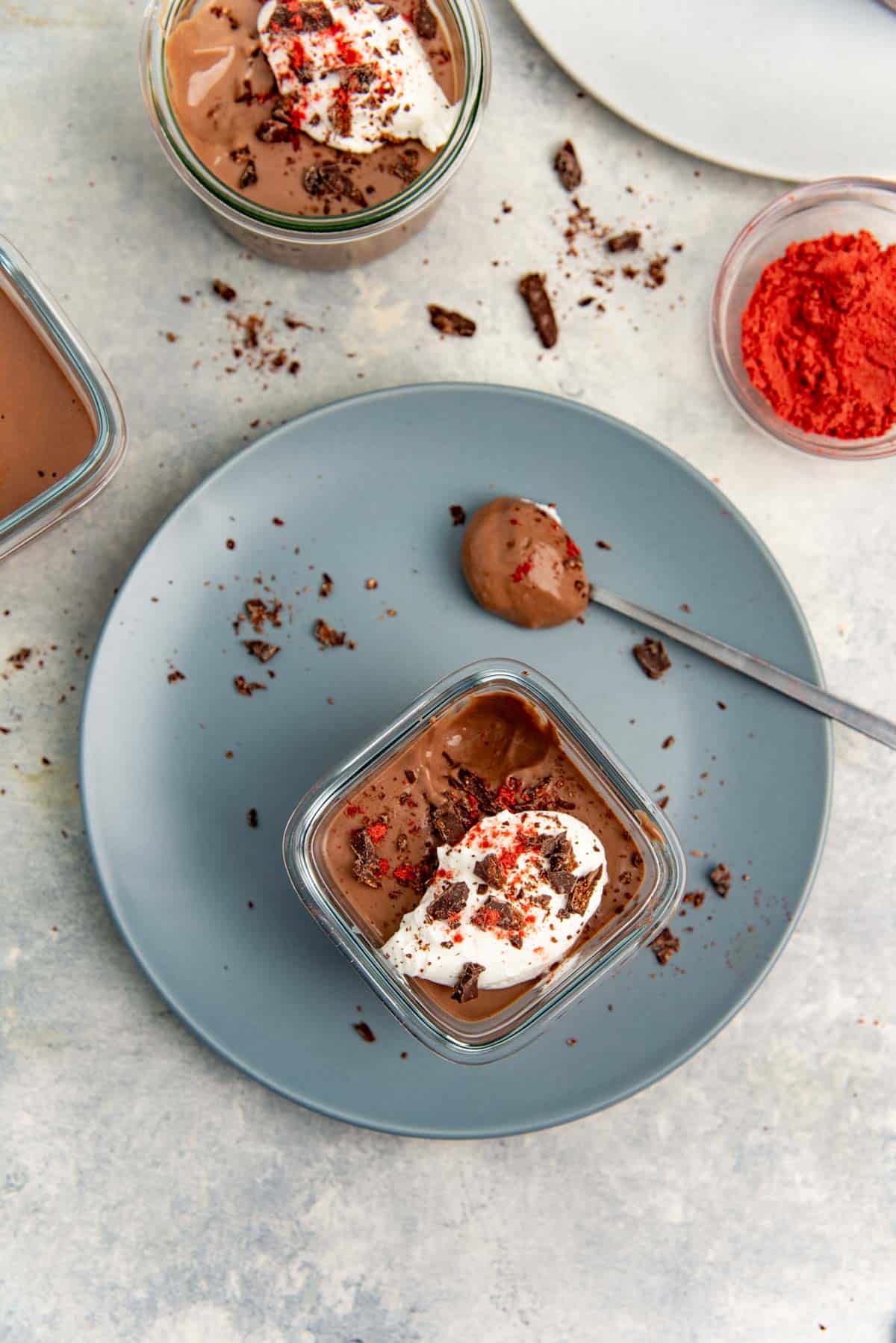Tofu chocolate mousse in a small glass container with a spoonful removed to show creamy texture.