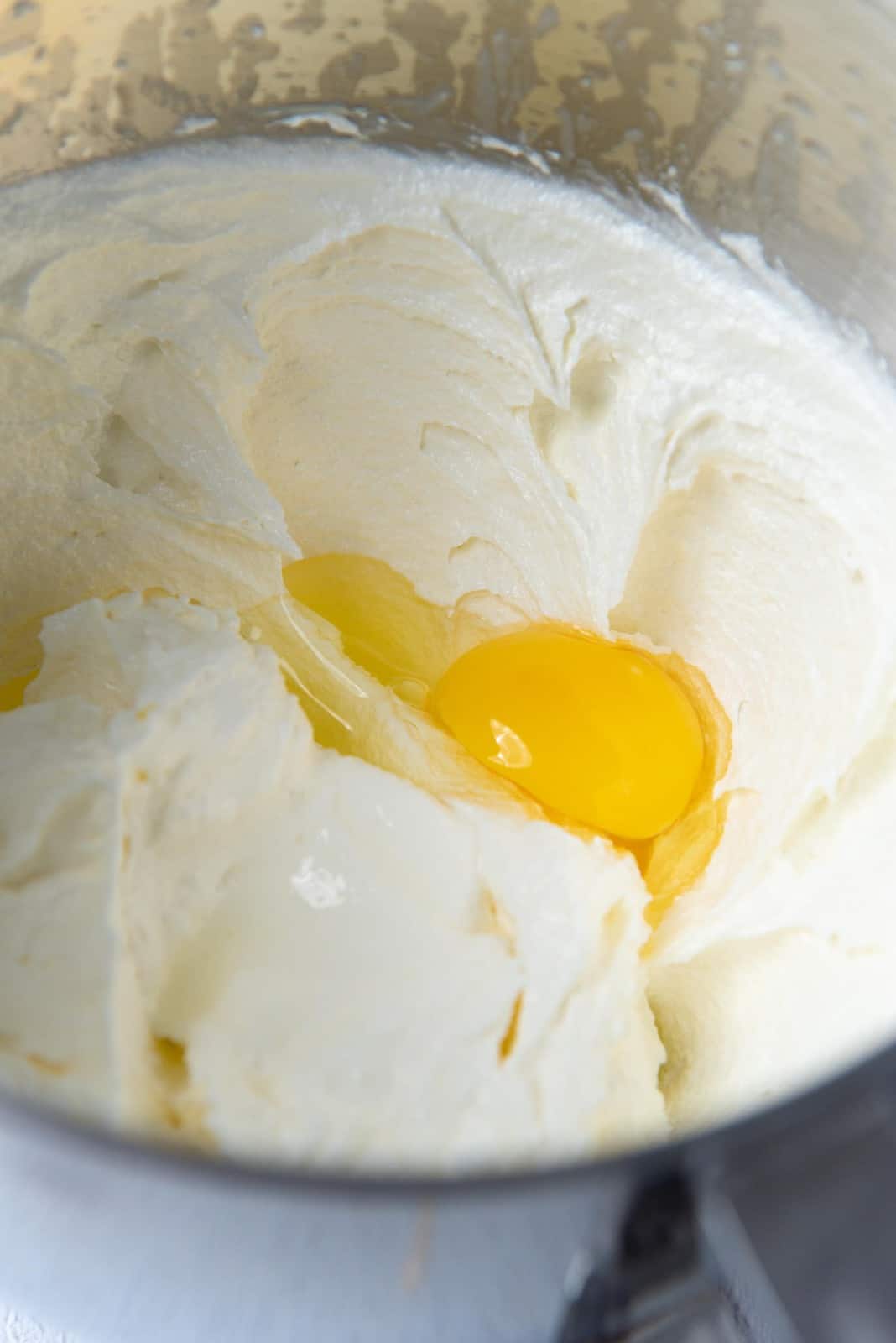 Adding eggs one at a time to the butter mix