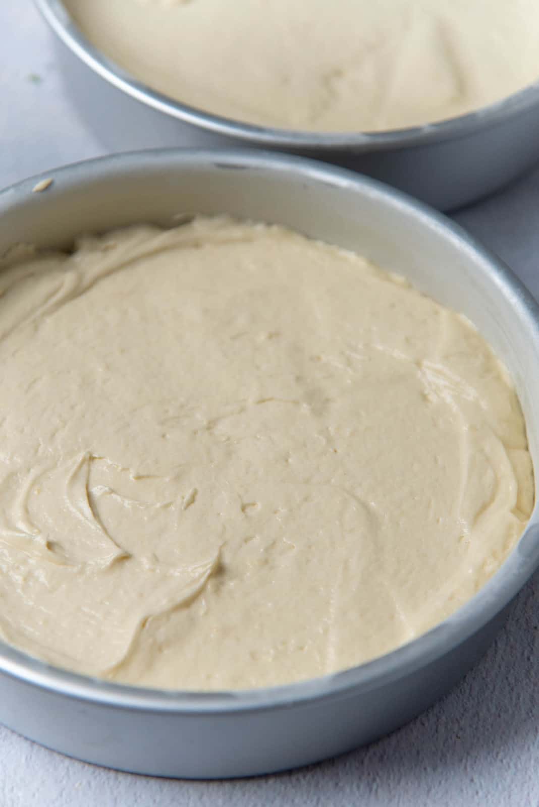 Cake batter evenly spread out in prepared cake pans
