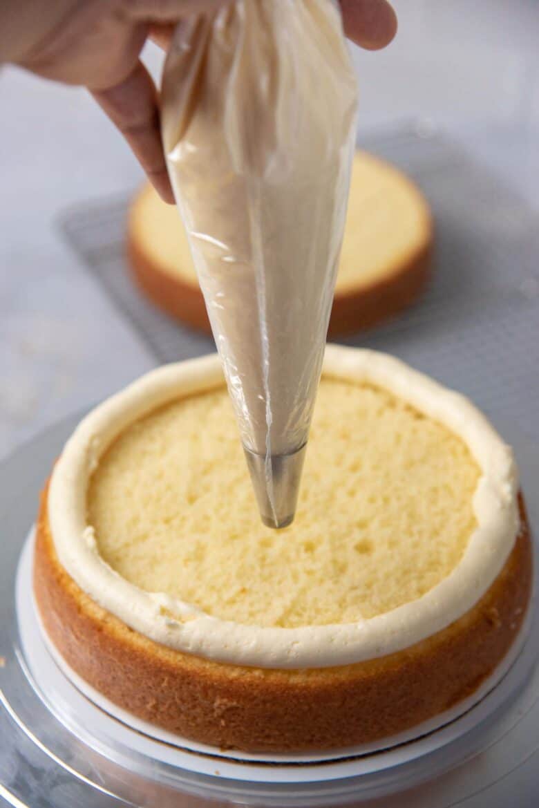 A buttercream dam piped on the edge of the cake layer