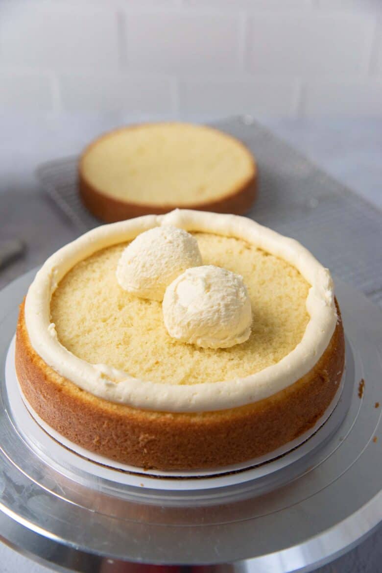 Using an ice cream scoop to evenly portion the vanilla buttercream