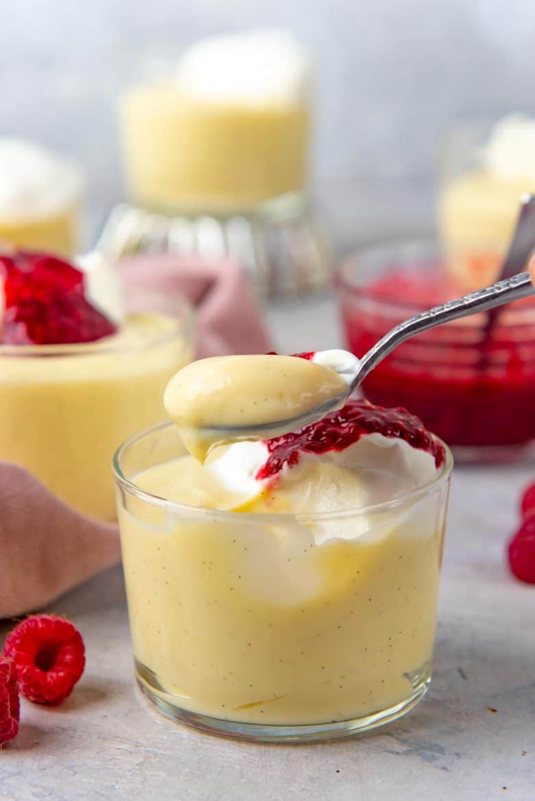 A spoonful of vanilla pudding over the bowl of pudding